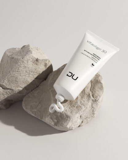 Vitaoligo 30 DU Cosmetics en tubo de 100 ml, crema hidratante con alta protección solar y extractos vegetales calmantes.